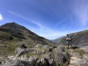 Will on mountain with bike on back