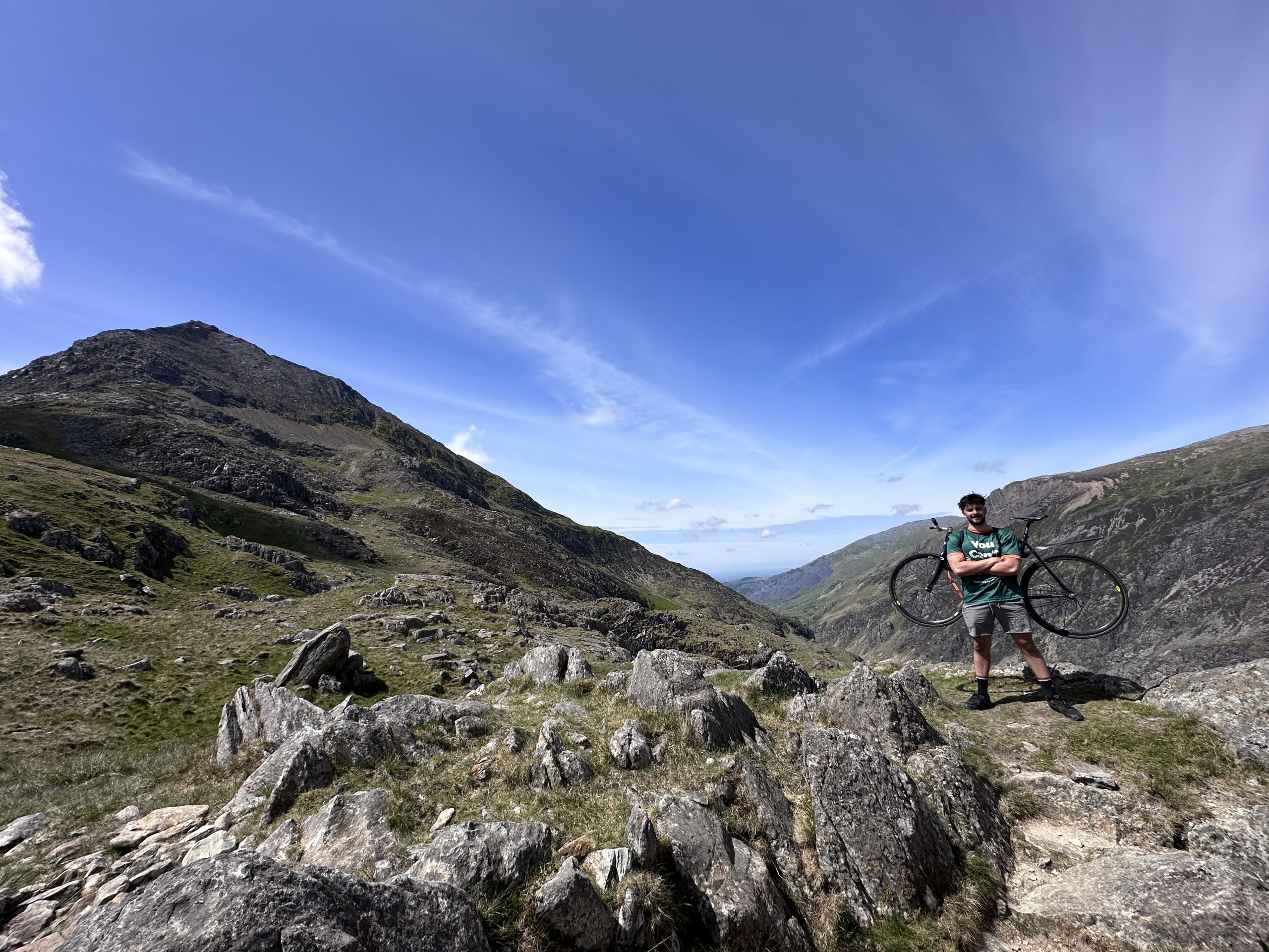 Will on mountain with bike on back