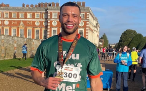 Photo of fundraiser, Patrick, holding his medal after his 10k race